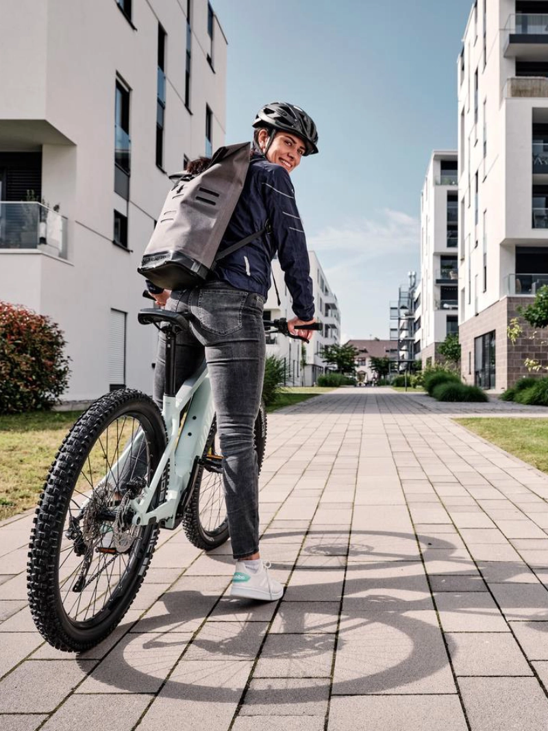 Eine JobRadlerin mit Mountainbike in einer Häuserschlucht